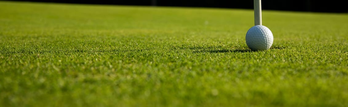 Golf ball and clubs in golf field