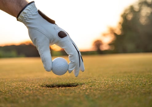 Golf course with ball and grass on close up of a hand     ,grass,golfer,golfing,sky,nature,ball,object,play,blue,fairway,closeup,club,outdoor     ,competition,recreation,background,color,summer