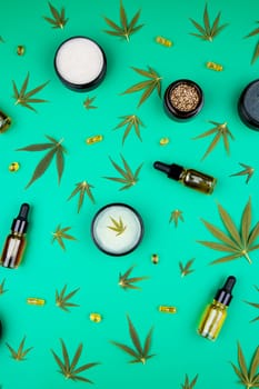 Flat lay composition of marijuana and hemp seeds on color green background
