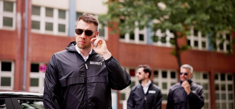 Diligent Security Agent in Corporate Setting, Safeguarding VIP Luxury Vehicles with Walkie Talkie in Business Environment