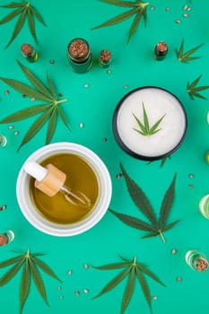 Flat lay composition of marijuana and hemp seeds on color green background