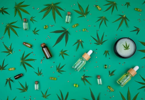 Flat lay composition of marijuana and hemp seeds on color green background
