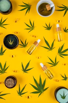 Set of cannabis oil bottles with hemp oil on yellow background. top view. flat lay