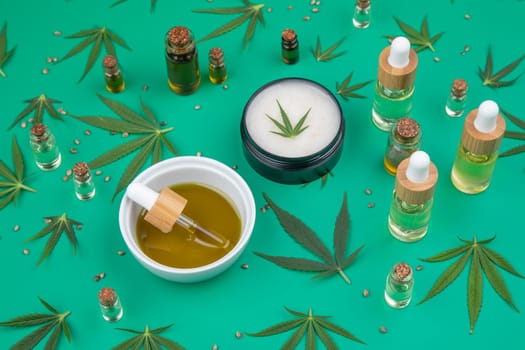 Flat lay composition of marijuana and hemp seeds on color green background