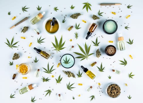 Flat lay composition with marijuana leaves, bottle of oil, cannabis on cbd, white background