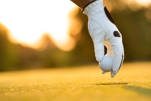 Golf course with ball and grass on close up of a hand     ,grass,golfer,golfing,sky,nature,ball,object,play,blue,fairway,closeup,club,outdoor     ,competition,recreation,background,color,summer