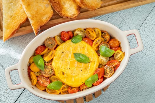 Baked camembert cheese with cherry tomatoes and basil