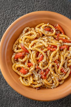 Bowl of udon noodles with bell pepper and mushrooms