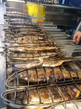 A fresh fish is grilled on a gas grill and sold at the market. Herring,trout,char,salted herring and mackerel. Tools are fish roaster,fish holder,fish grill and grill basket.