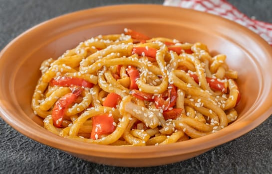 Bowl of udon noodles with bell pepper and mushrooms