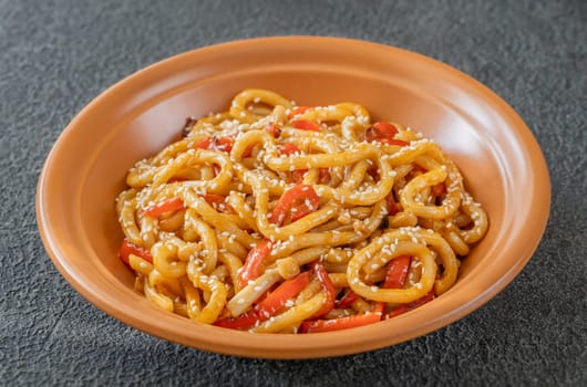 Bowl of udon noodles with bell pepper and mushrooms