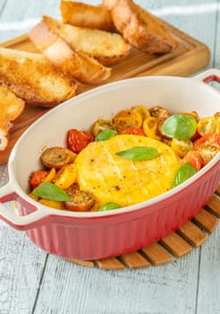 Baked camembert cheese with cherry tomatoes and basil