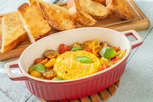 Baked camembert cheese with cherry tomatoes and basil