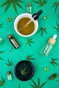 Flat lay composition of marijuana and hemp seeds on color green background
