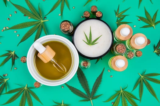 Flat lay composition of marijuana and hemp seeds on color green background