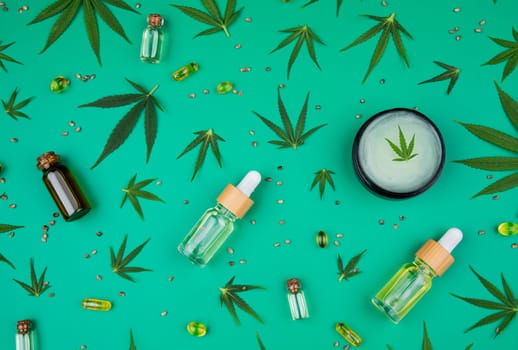 Flat lay composition of marijuana and hemp seeds on color green background