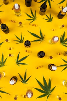 Set of cannabis oil bottles with hemp oil on yellow background. top view. flat lay