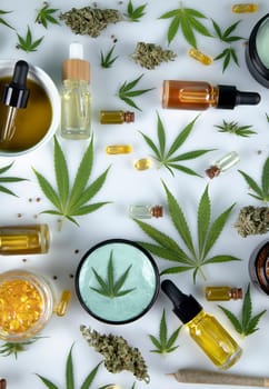Flat lay composition with marijuana leaves, bottle of oil, cannabis on cbd, white background