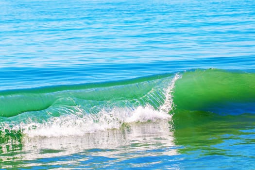 Ocean wave background texture. A wave breaks on the coast. Beautiful azure blue Atlantic Ocean.