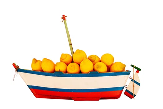Old wooden model sailing ship with a load of freshly harvested lemons isolated on a white background. Clipping path. Health concept.