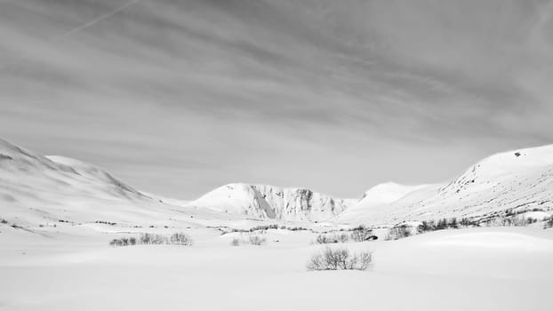 Norwegian high mountains in the snow. Mountains covered in snow. Taken in black and white. Scandinavian landscape in the far north
