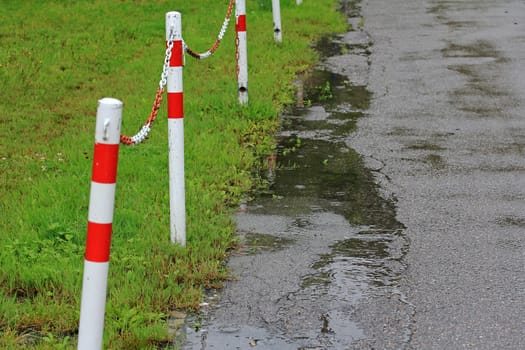 Eine regennasse Straße mit einer Absperrung
