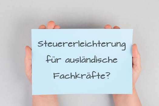 Tax relief for foreign skilled workers is standing in german language on the paper, new law in Germany for immigrants and asylum seekers