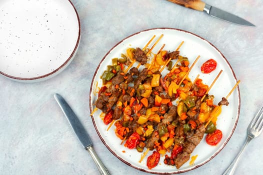 Lamb skewers with vegetables. Kebabs or lamb shish kebab. Lamb meat on skewer. Top view.