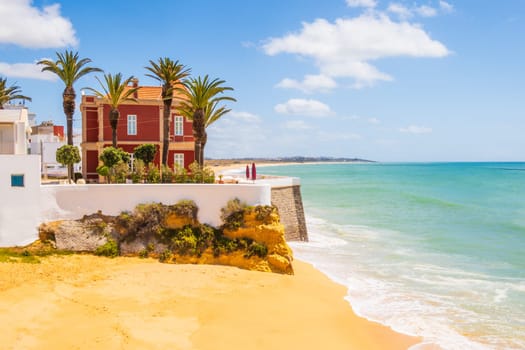 View of palm trees and beach in Armação de Pêra, Algarve, Portugal
