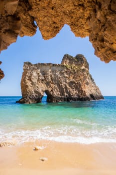 Small, heavenly and difficult to access beach vertically photographed from inside the rocks, near Portimão in the Algarve region of Portugal