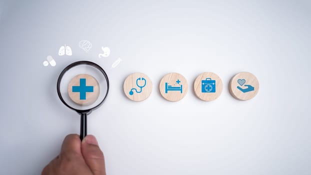 Human hands hold a magnifying glass and focus on the plus sign and healthcare medical icon on white background, Health insurance concept, Health and access to welfare health concept.
