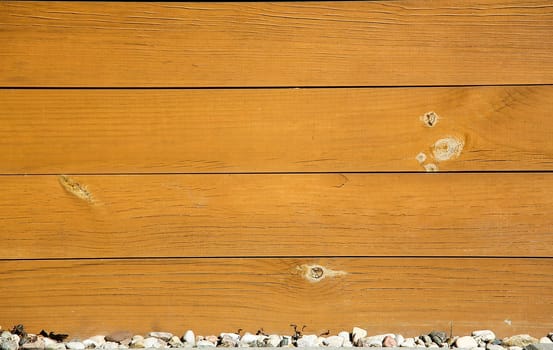 Close-up of horizontal wooden planks with rustic texture above a row of small stones, background image