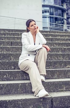 pensive young woman sitting on a staircase
