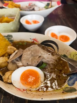 Hot and spicy Thai noodle soup with soft boiled egg, stock photo