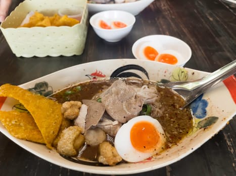 Hot and spicy Thai noodle soup with soft boiled egg, stock photo