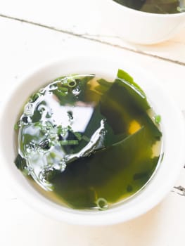 Miso soup with tofu and wakame seaweed on the table, stock photo