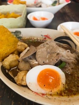 Hot and spicy Thai noodle soup with soft boiled egg, stock photo