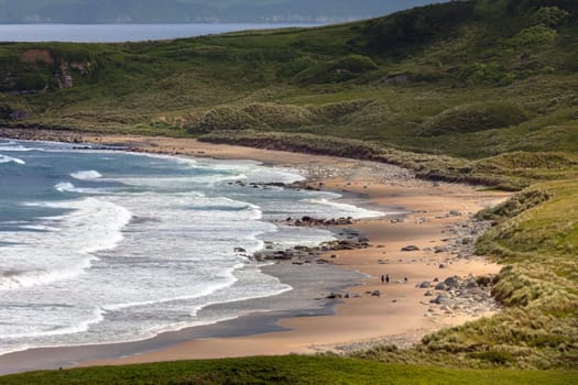 White Park Bay (also spelled Whitepark Bay) has three-mile long beach near Ballycastle, County Antrim on the north coast of Northern Ireland. Sheep and cattle graze the hills and beach along the bay, which has been under the care of the National Trust for Places of Historic Interest and Natural Beauty since 1938
