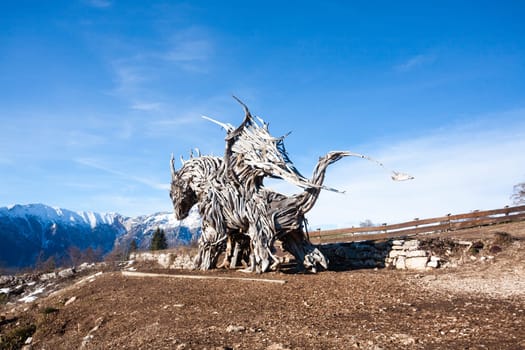 Wooden sculpture of a dragon made of tree branches. Vaia tempest dragon