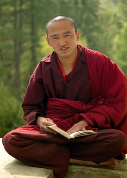 A monk reading his lessons near Paro Dzong in the Kingdom of Bhutan