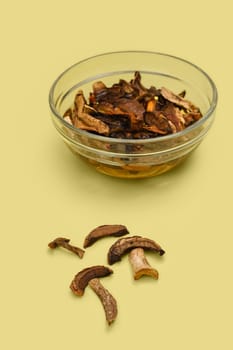 Dried forest mushrooms soaking in bowl with water