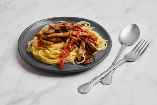 Plate with spaghetti with mushrooms and pork in sticky sauce