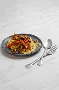 Plate with spaghetti with mushrooms and pork in sticky sauce