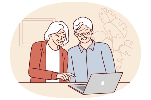 Elderly men and women are sitting at table with laptop learning how to handle modern technology and computer literacy. Elderly couple make video call to children using laptop with internet