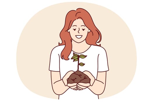 Woman holds handful of earth with plant drawing attention to problem of ecology and pollution or CO2 emissions. Happy girl doing plant cultivation and care for environment or ecology as volunteer