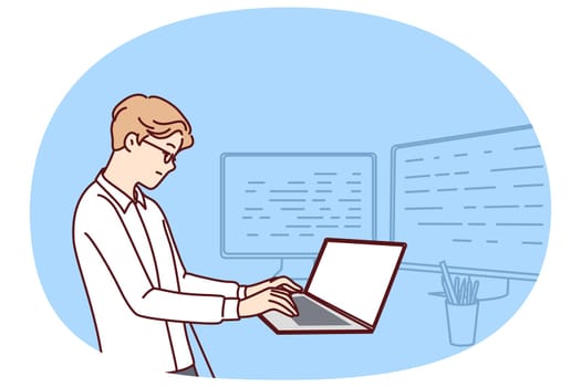 Man software developer is standing at table with laptop and monitors creating server applications. Dispatcher guy works as it analyst using software to monitor load on company computer systems.