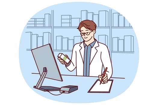 Man pharmacist in white medical coat stands behind counter in pharmacy and prescribes prescription drugs to patients. Pharmacy employee makes notes in notebook choosing antibiotics or vitamins