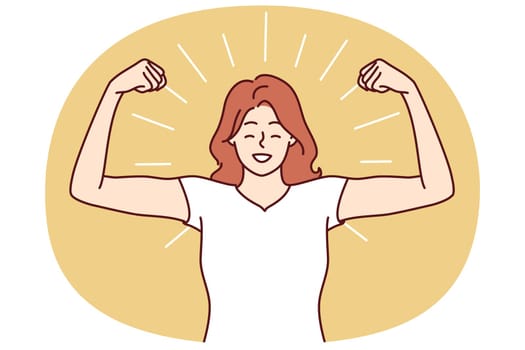 Woman shows biceps and smiles standing in strongman pose to demonstrate self-confidence and readiness for new achievements. Girl boasts biceps after going to fitness room and training with trainer
