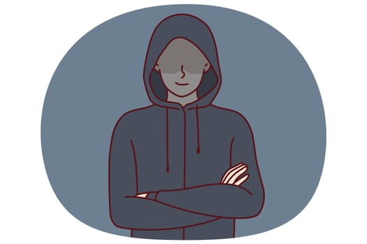 Anonymous man stands with arms crossed and hiding eyes behind hood for concept of secret surveillance or banditry. Anonymous guy hiding face wanting to remain incognito planning illegal activities