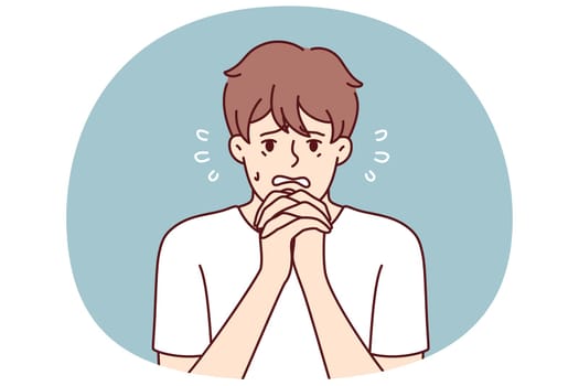 Excited man makes gesture of praying asking lord for help in solving problems that have arisen. Frightened guy praying and begging god to help him recover from disease or be saved for sinful act